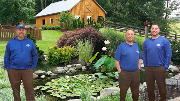 Three Members of The Pond Crew Standing In Front of Pond